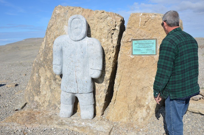 Man looking at Arctic Exiles monument 1